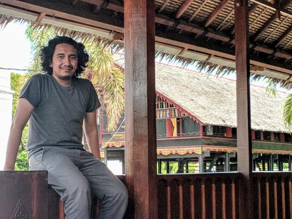 Dimas Romadhon sitting on a railing in Aceh Indonesia