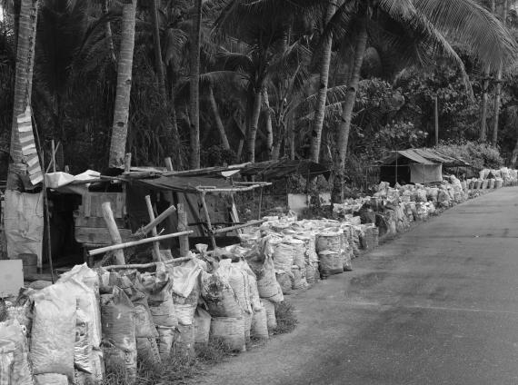 Breakers' huts and bags of krikil for sale line the road near Dobo.