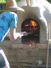 Students making pizza in a wood-fired cob oven