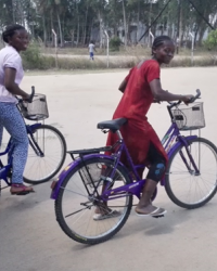 Two Mozambican community activists on bikes heading to do home visits to people in the community living with HIV.