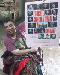 Willy Morales, indigenous male and leader of RENPO, holding one of the latest campaign posters. He is in a wheelchair.