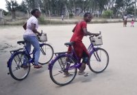 Two Mozambican community activists on bikes heading to do home visits to people in the community living with HIV.