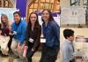 A collage of photos, one with a group of students and two photos with two students each standing in front of their presentation