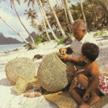 Photo on a beach in Samoa of a fisherman and boy with a basket